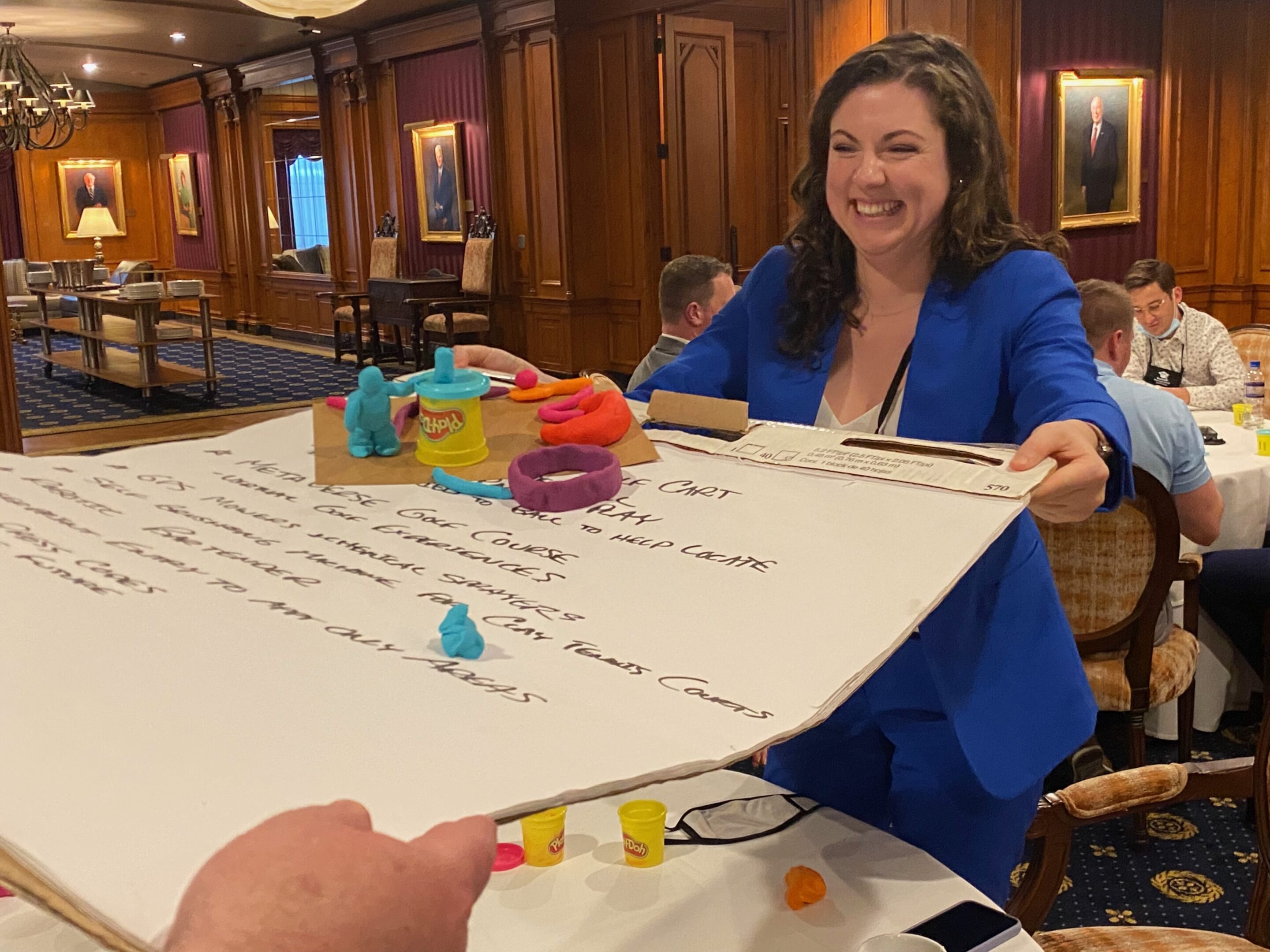 Smiling woman holding a large presentation board.