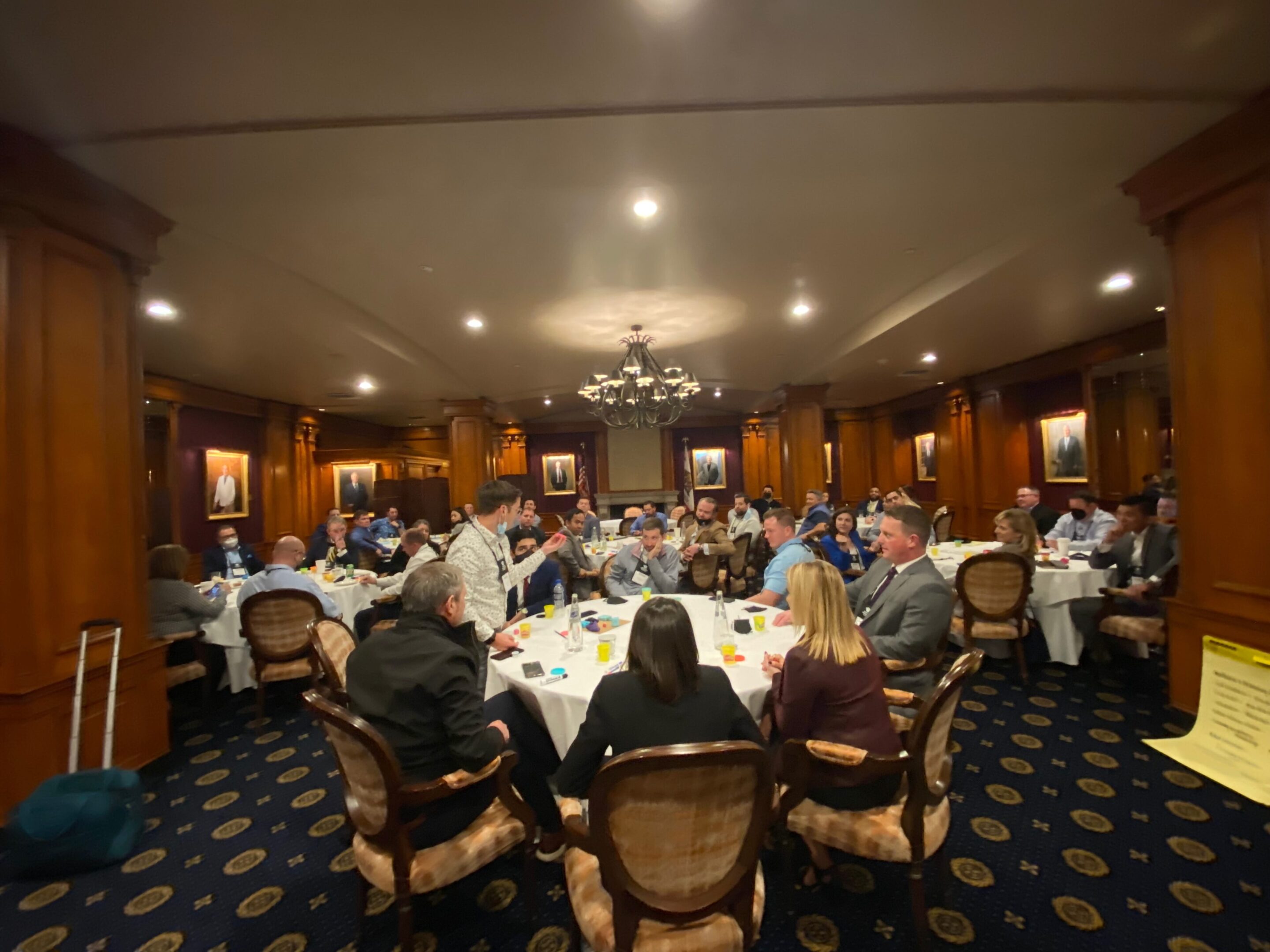 People seated in a formal meeting room.