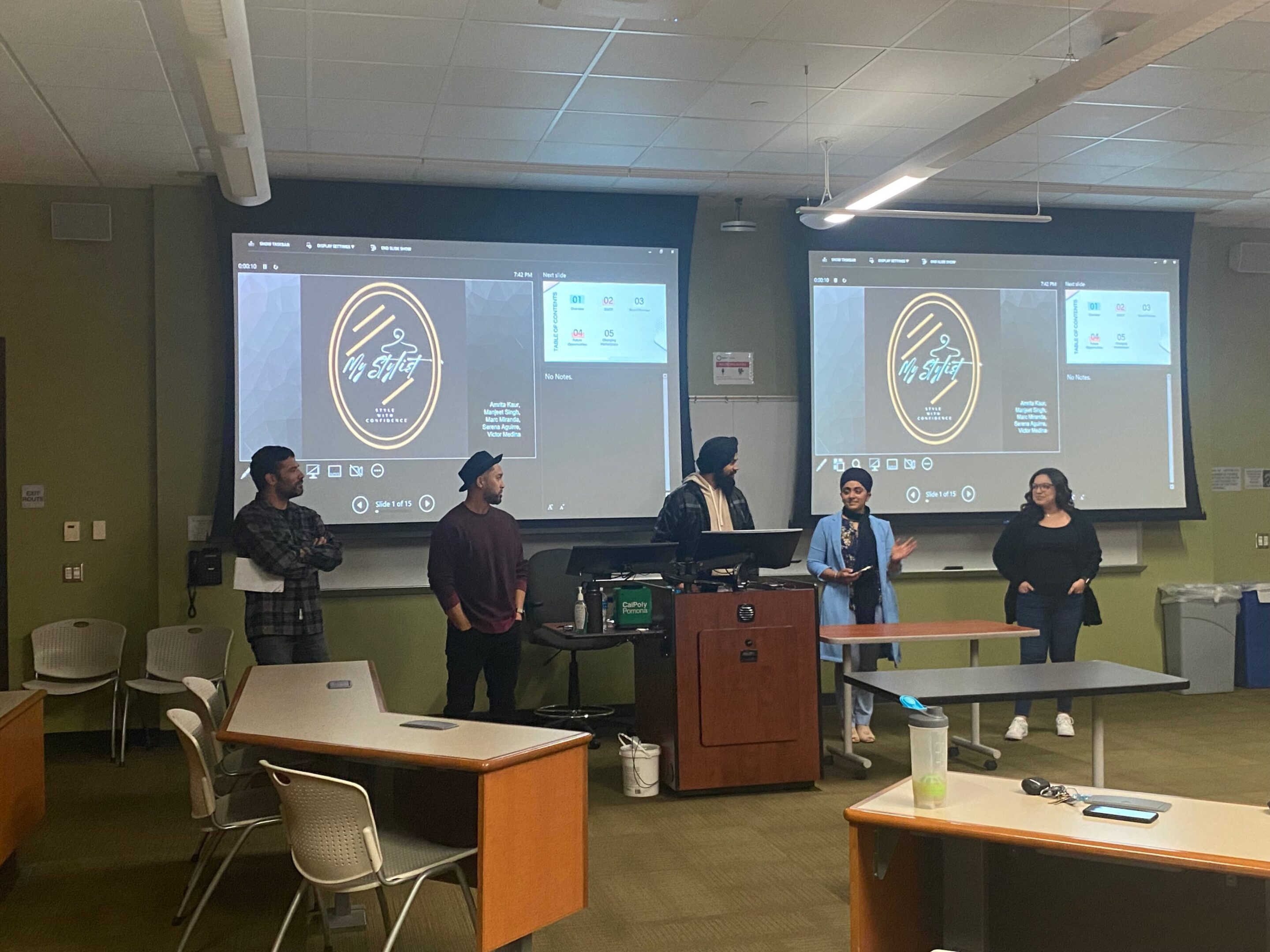 People presenting in a classroom with screens.
